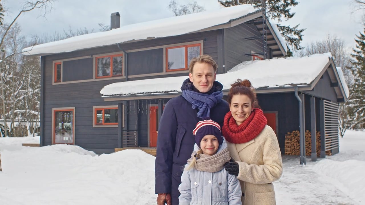 Familie vor einem Finnlog Holzhaus im Winter